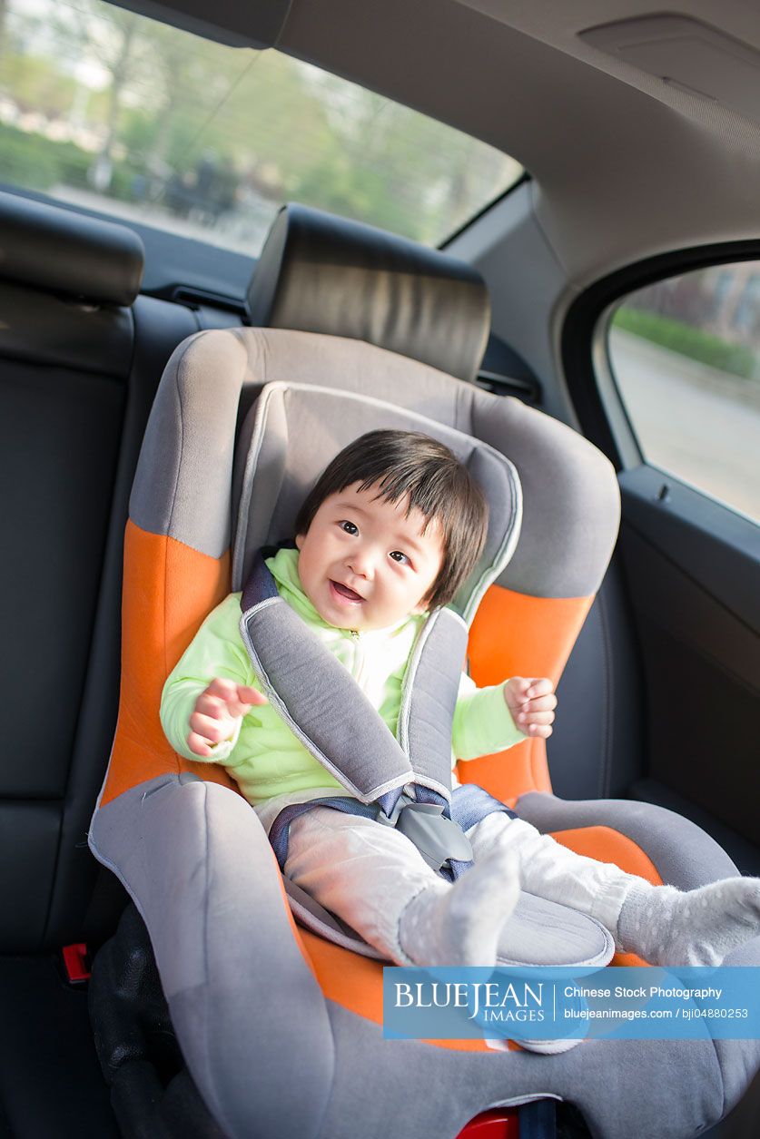 Cute Chinese baby sitting in car back seat