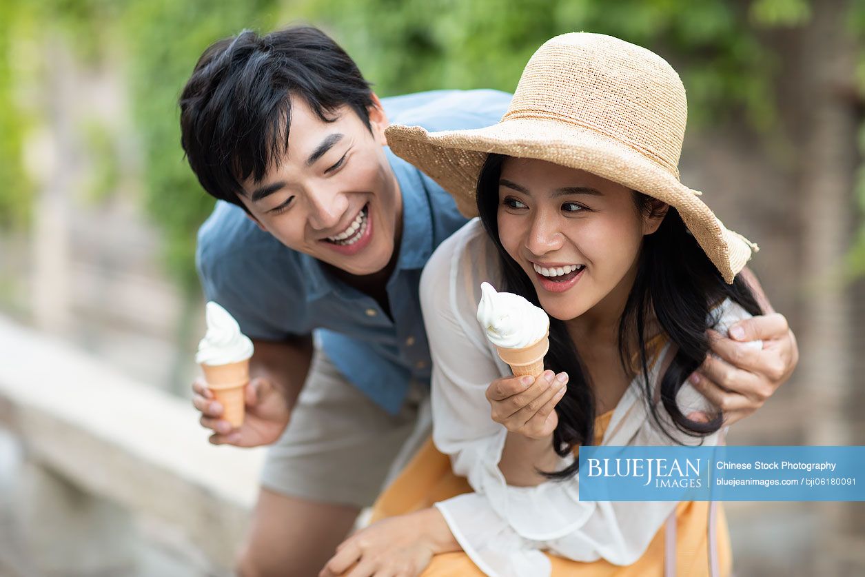 Happy young Chinese couple eating ice cream