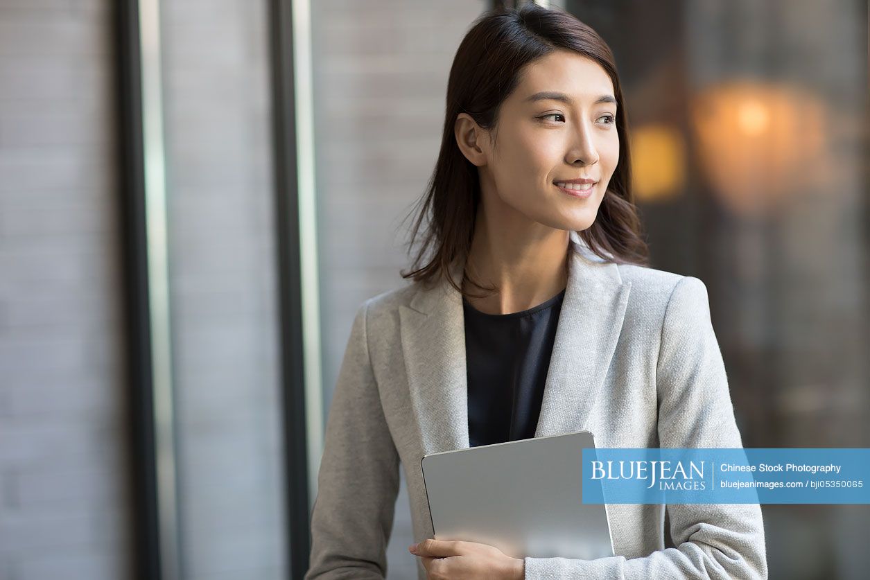 Young Chinese businesswoman holding a digital tablet