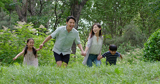 Happy young Chinese family playing on grass,4K