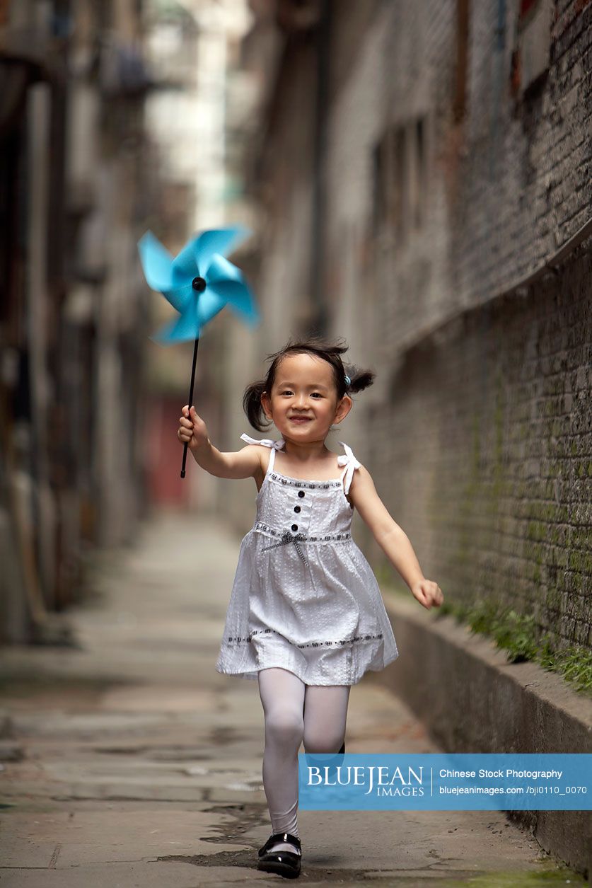 Chinese child running with a paper pinwheel