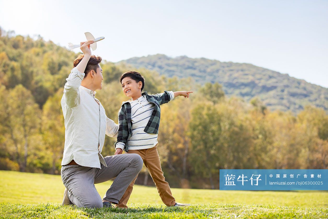 快乐的的父子俩在草地上玩耍