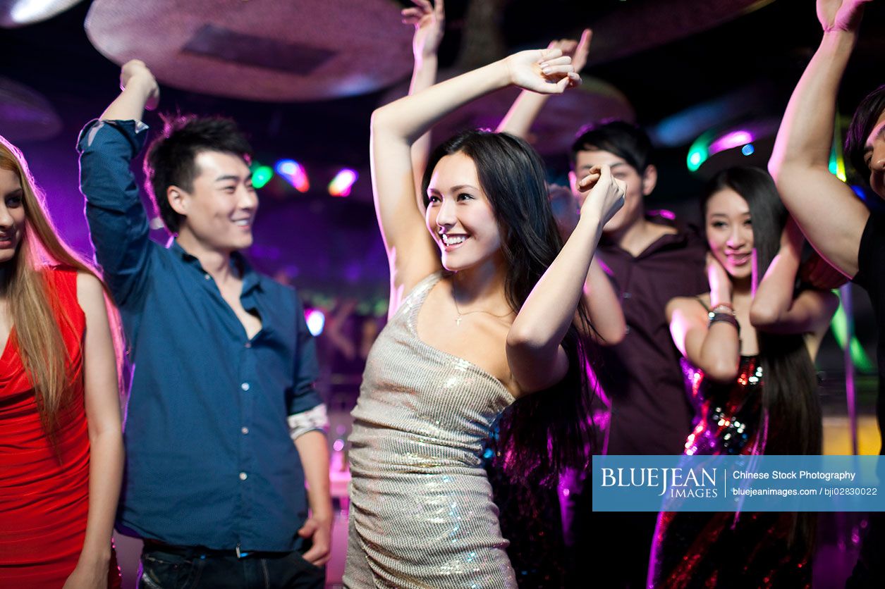Stylish young Chinese dancing in nightclub