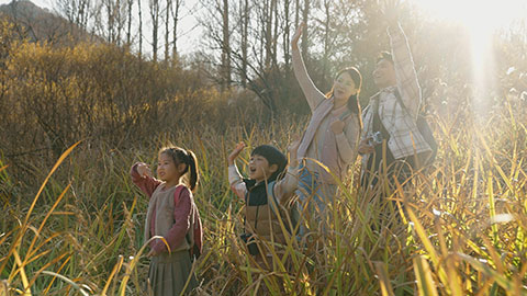 Happy young Chinese family hiking outdoors