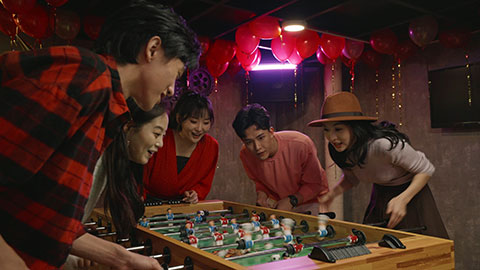 Happy young Chinese friends playing table football,4K