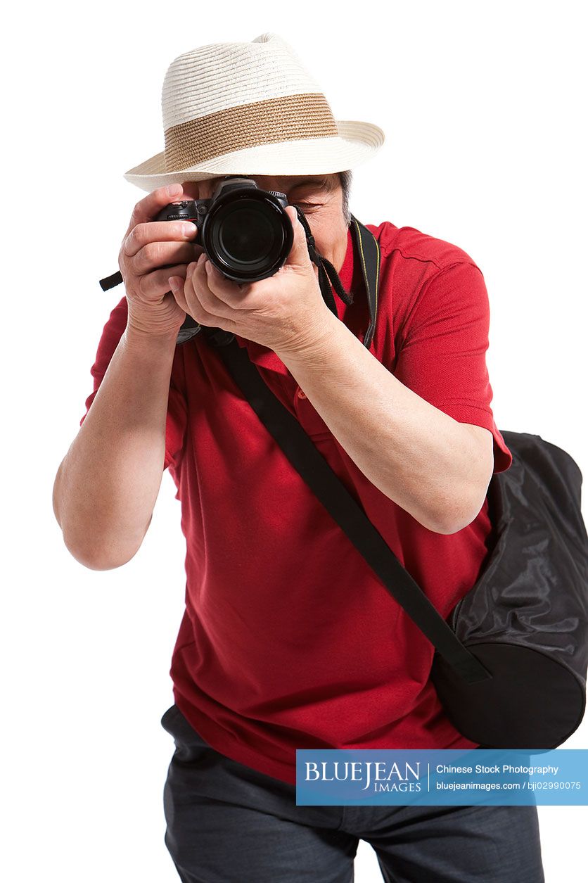 Portrait of senior Chinese man holding a camera