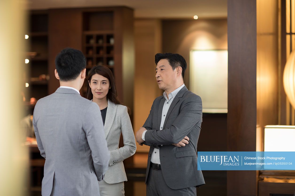 Cheerful Chinese business people talking indoors