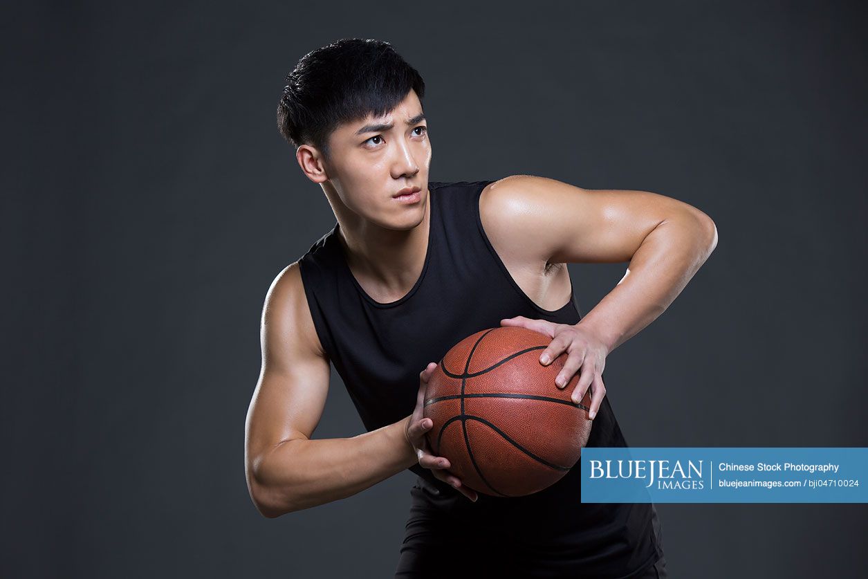 Young Chinese man playing basketball