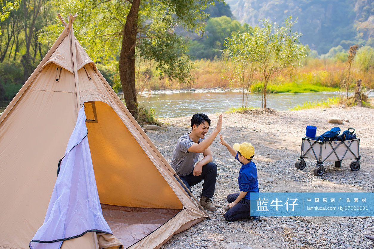 可爱的男孩和爸爸在户外搭露营帐篷