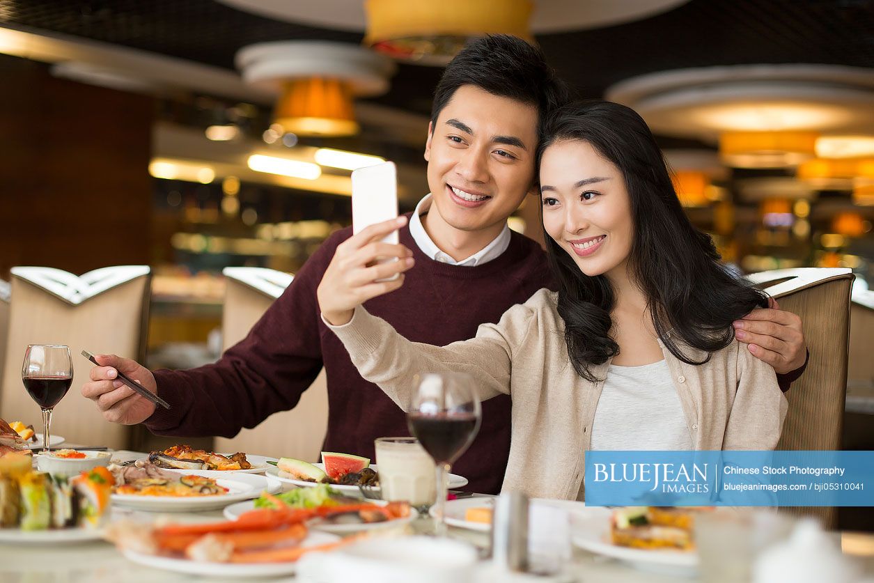 Cheerful young Chinese couple having buffet dinner