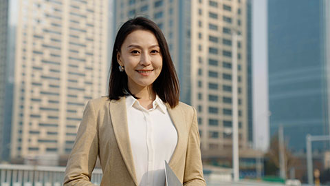 Confident Chinese businesswoman standing outdoors