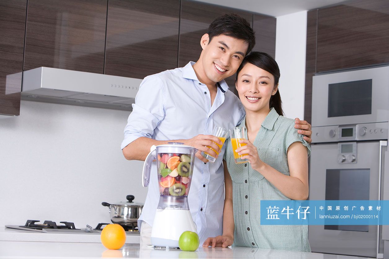 青年夫妇在厨房做鲜榨果汁