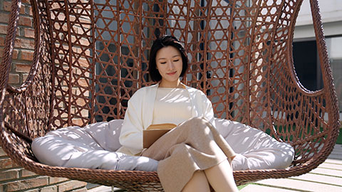 Happy young Chinese woman reading on hanging-chair,4K