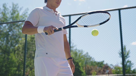 Mature Chinese man playing tennis ball
