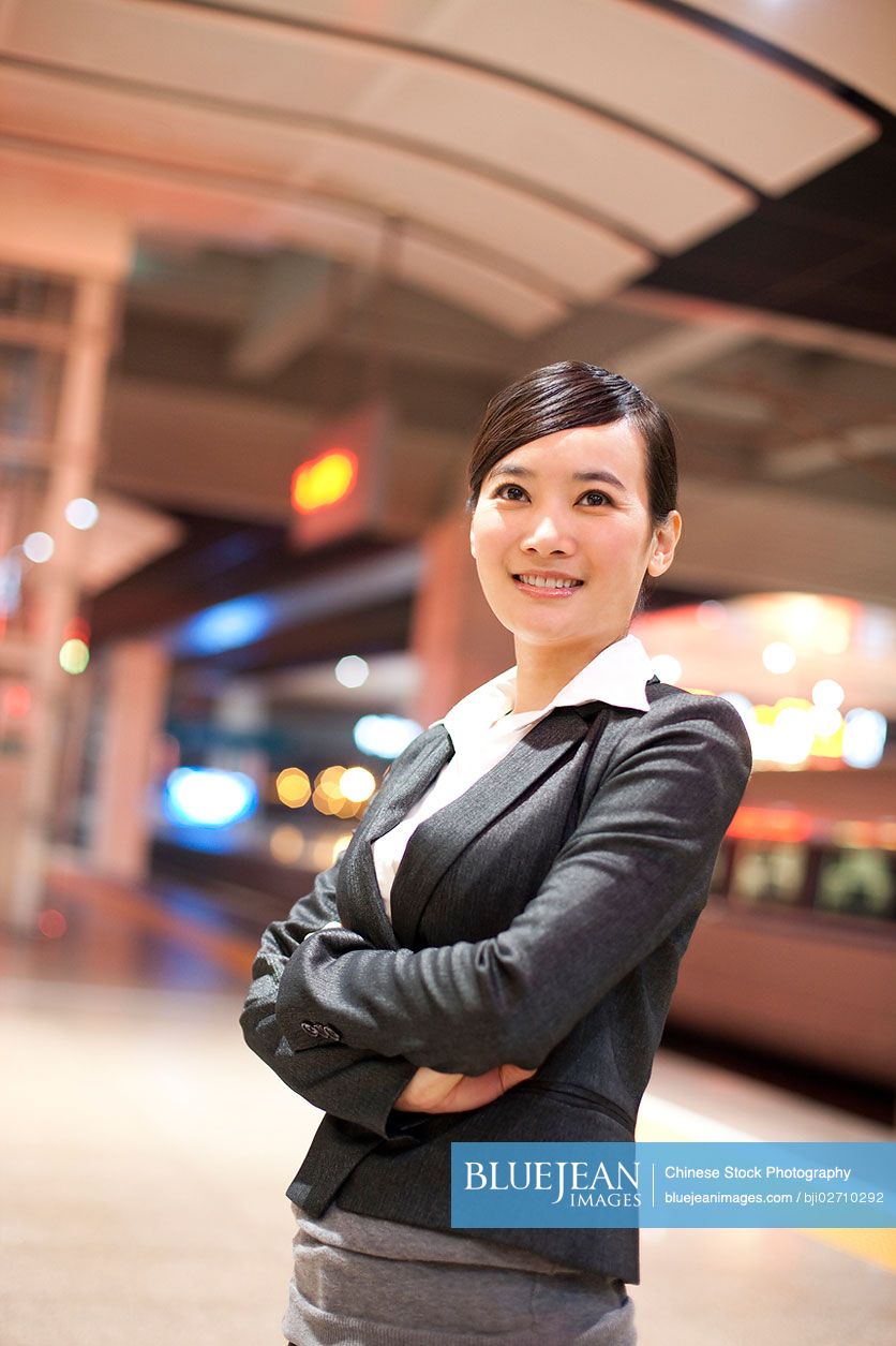 Young Chinese businesswoman contemplating at the train station