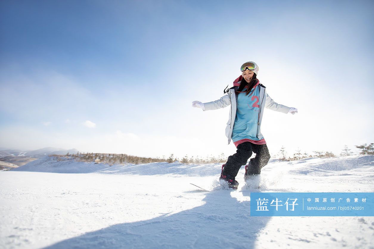 快乐的年轻女士在滑雪场滑雪