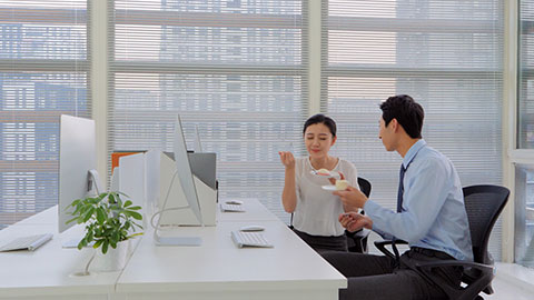 Young Chinese business people eating dessert in office,4K