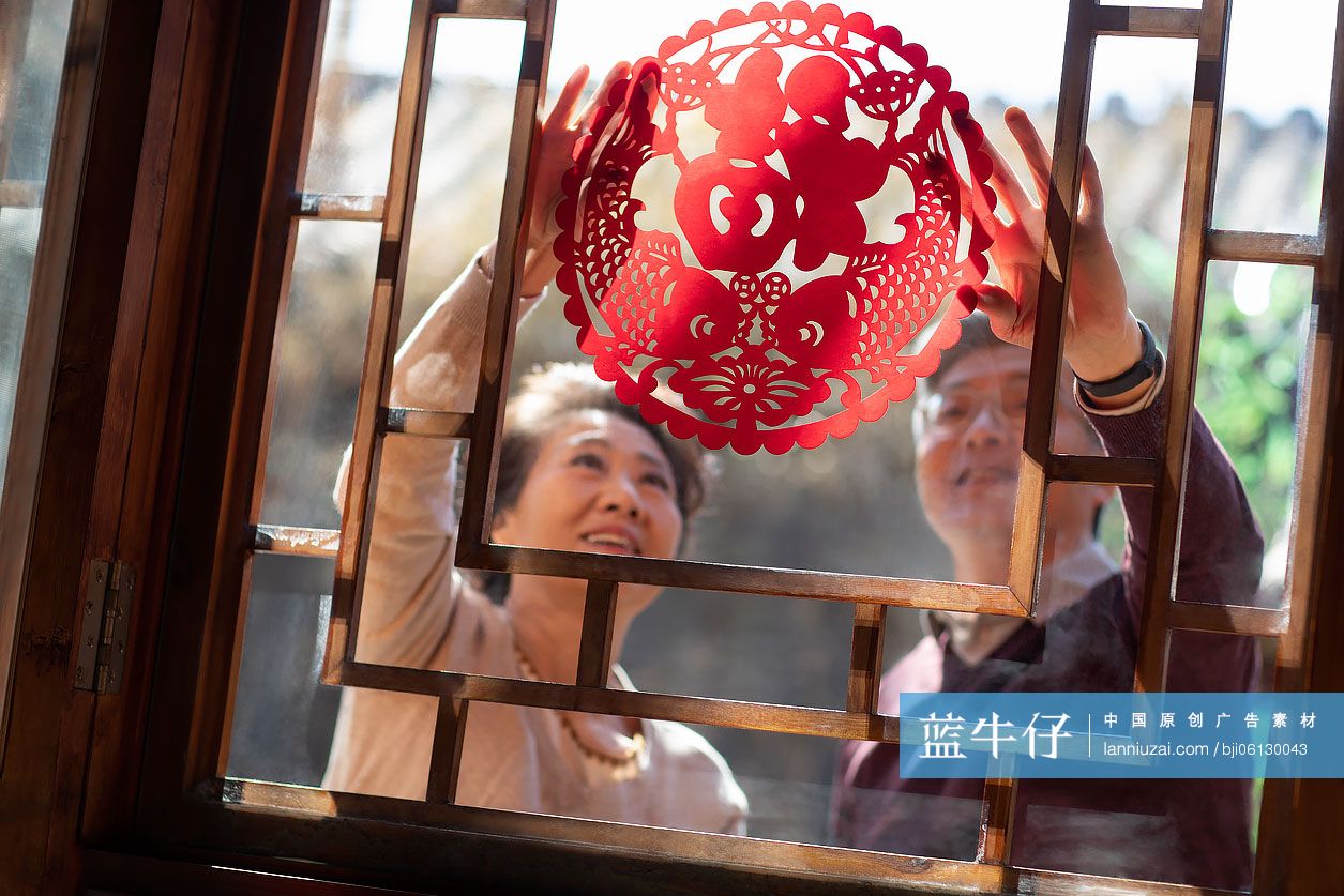 老年夫妇一起贴窗花