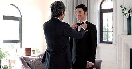 Senior Chinese father adjusting bowtie for his son,4K