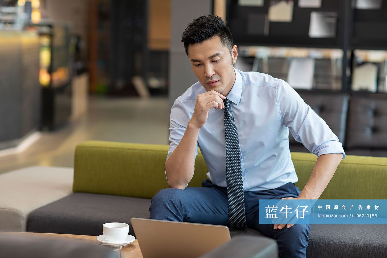 商务男士在咖啡馆使用笔记本电脑工作