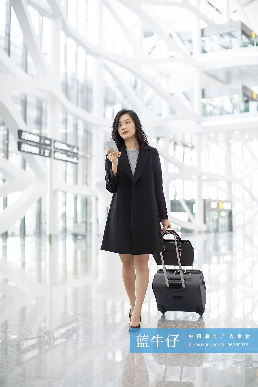 年轻商务女士在机场使用手机