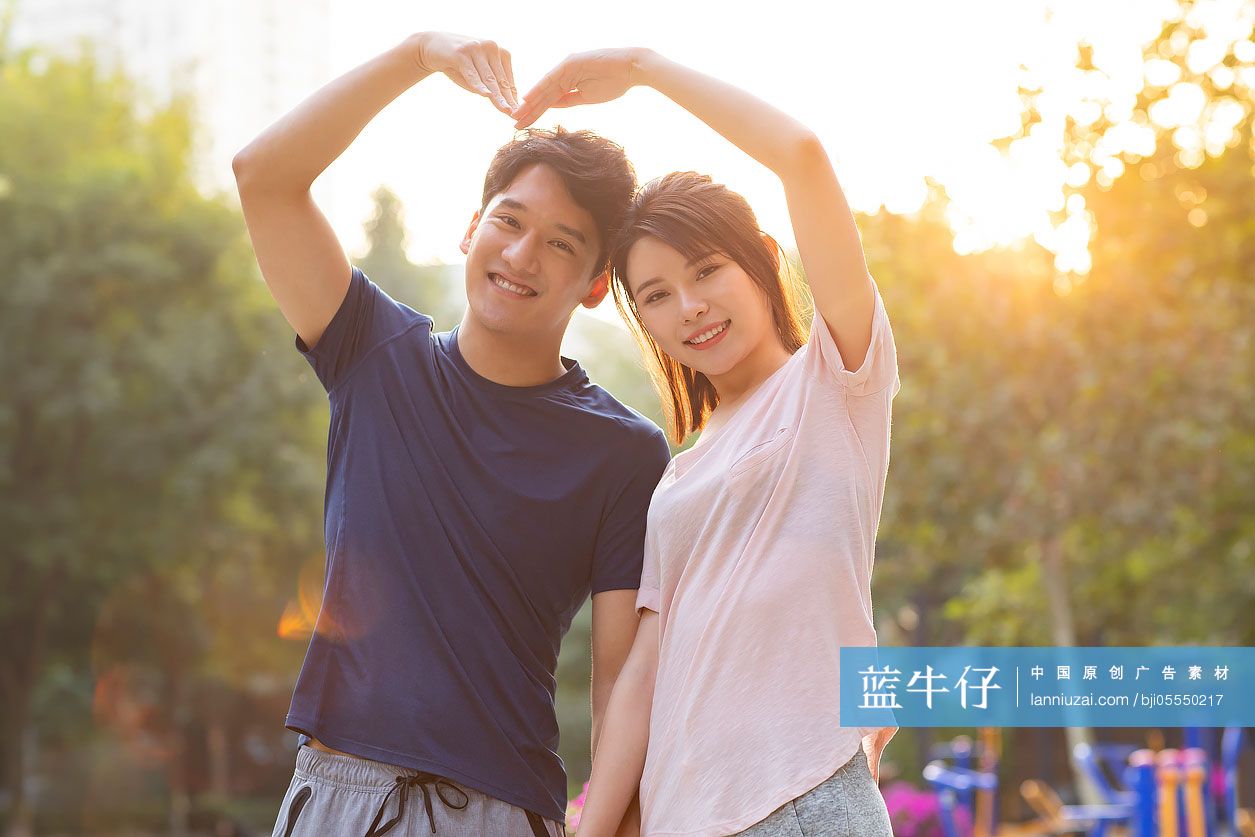 开心的年轻情侣摆心型手势