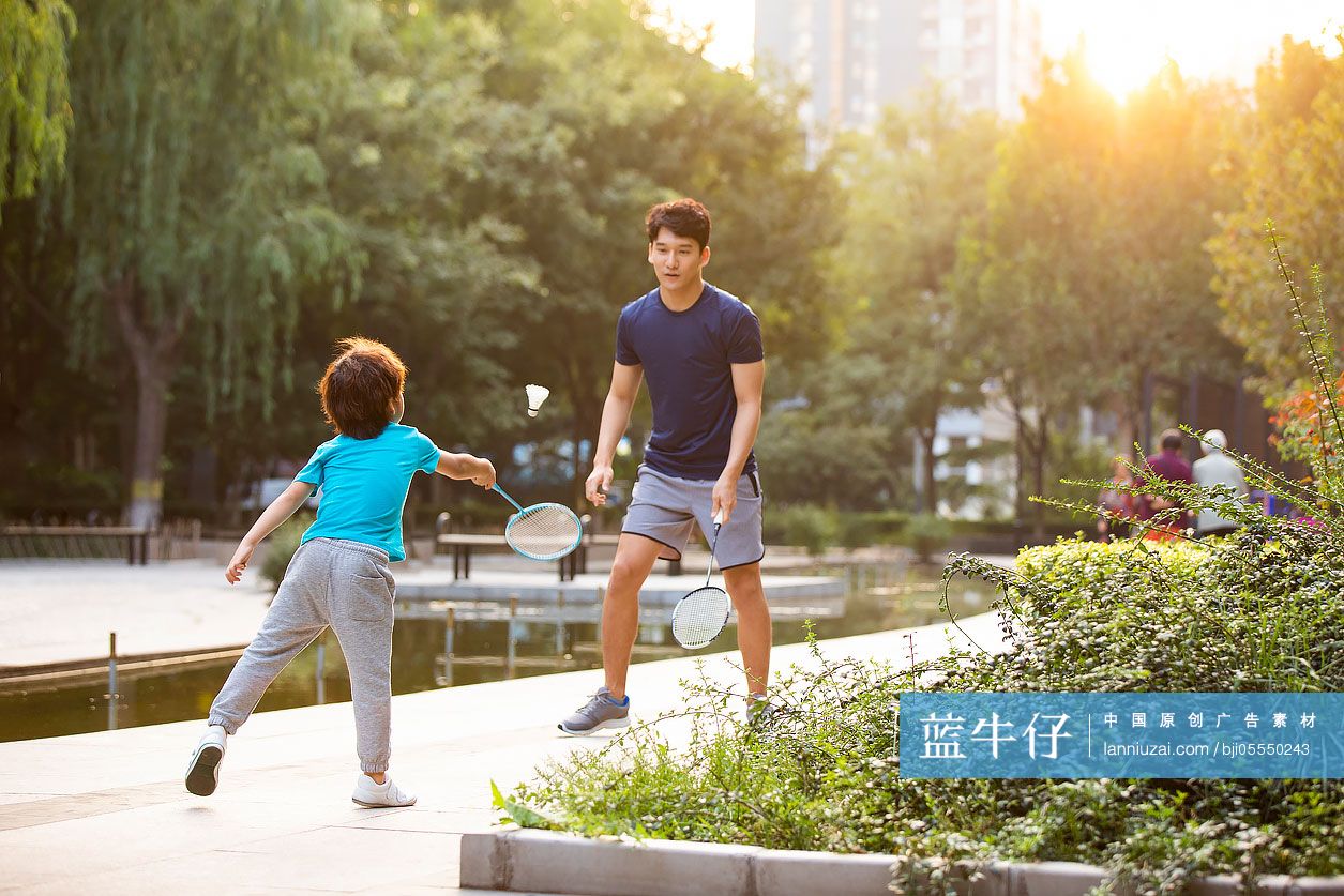 开心的父子俩在公园打羽毛球