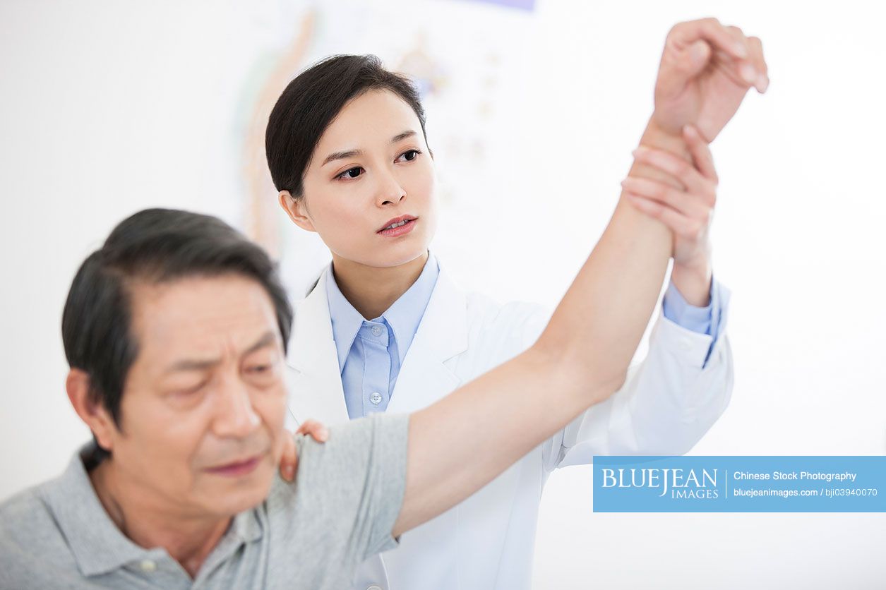 Female Chinese doctor examining senior patient