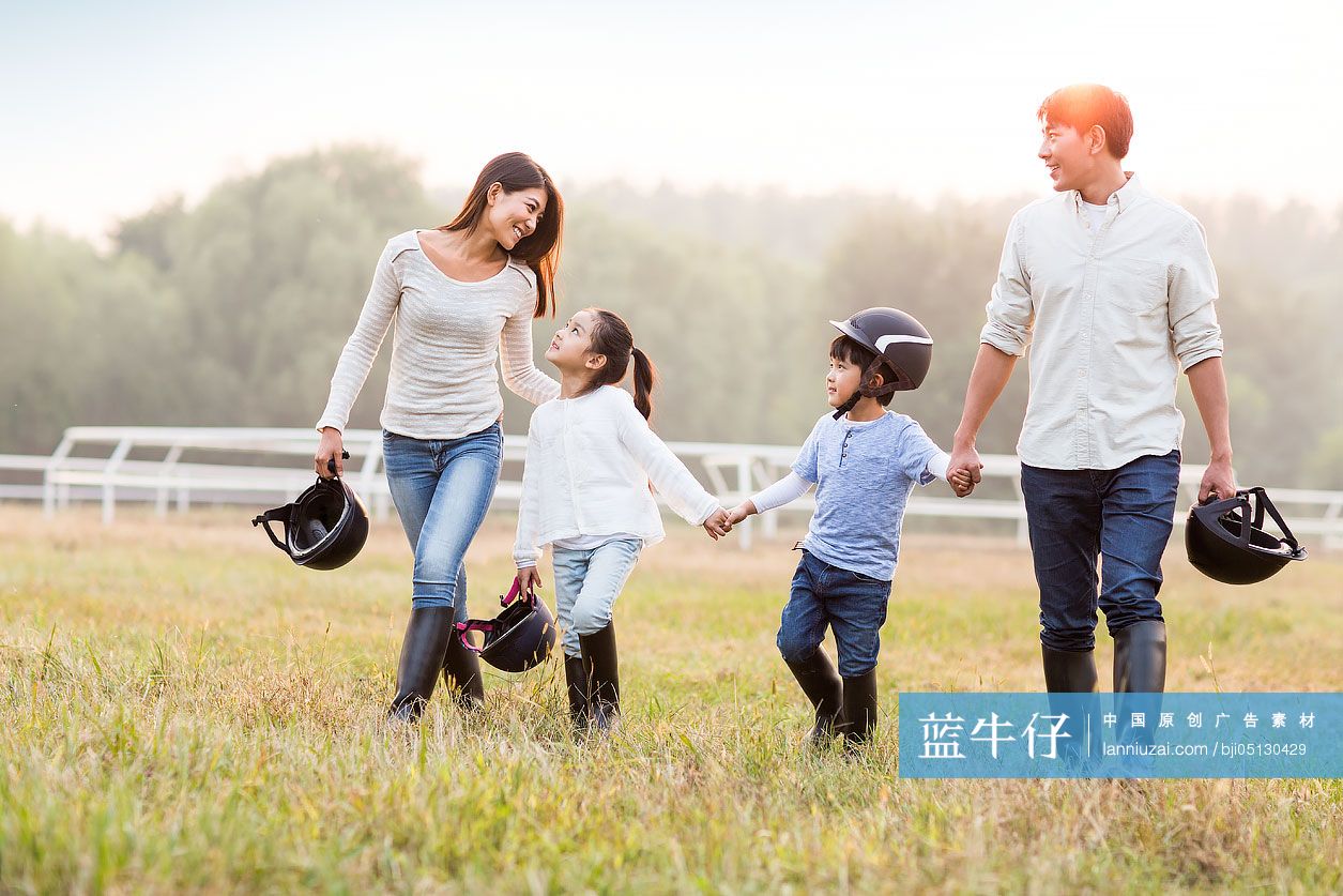年轻父母带着儿女在马场玩
