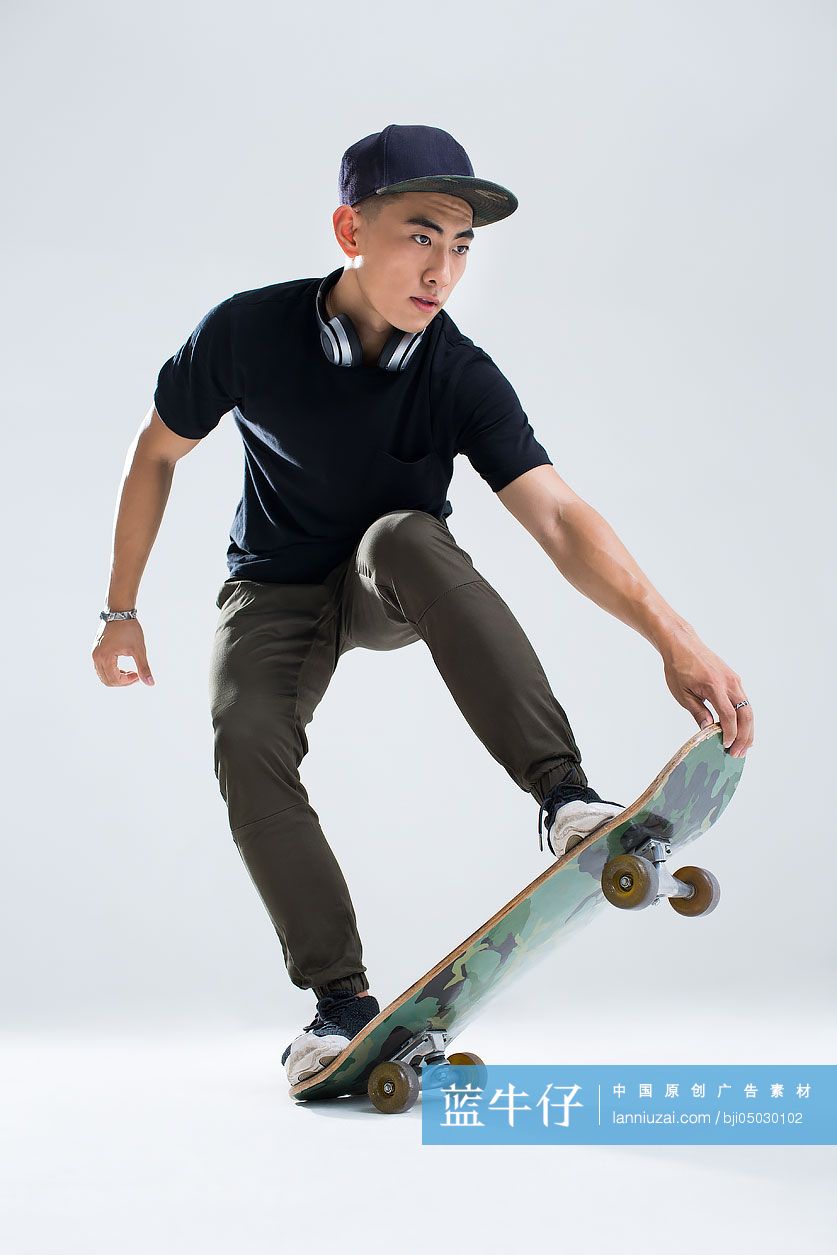 戴耳机的年轻男子在滑滑板