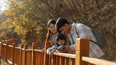 Cheerful young Chinese family enjoying the beautiful natural scenery