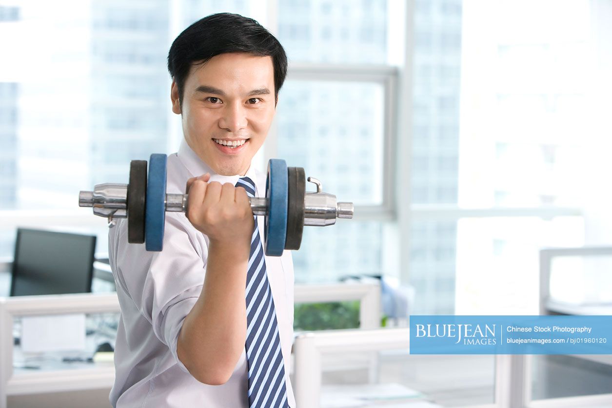 Chinese office worker working out in the office