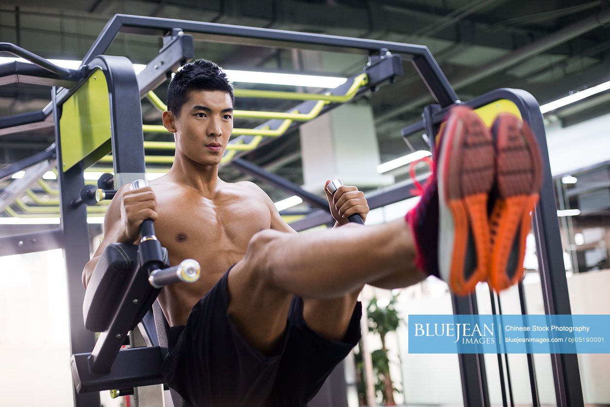 Young Chinese man exercising at gym