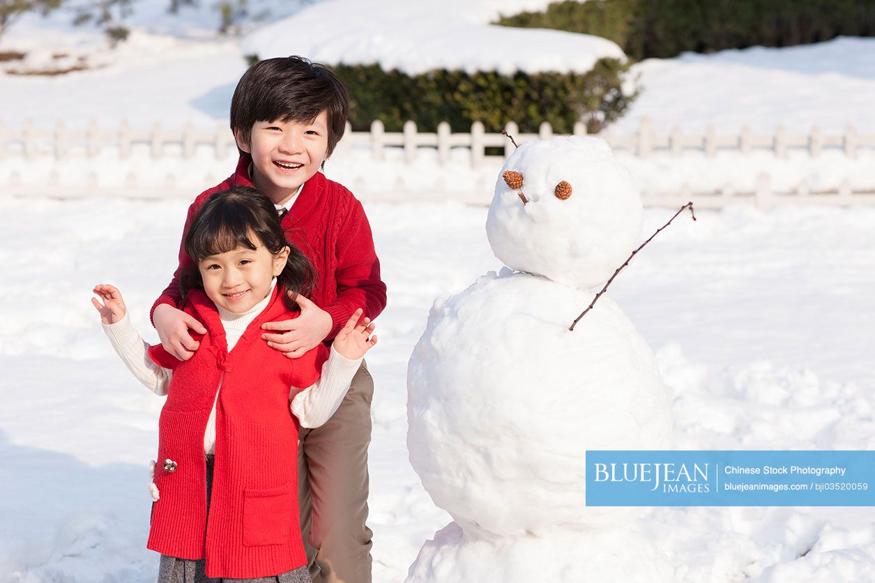 Cheerful Chinese kids with snowman
