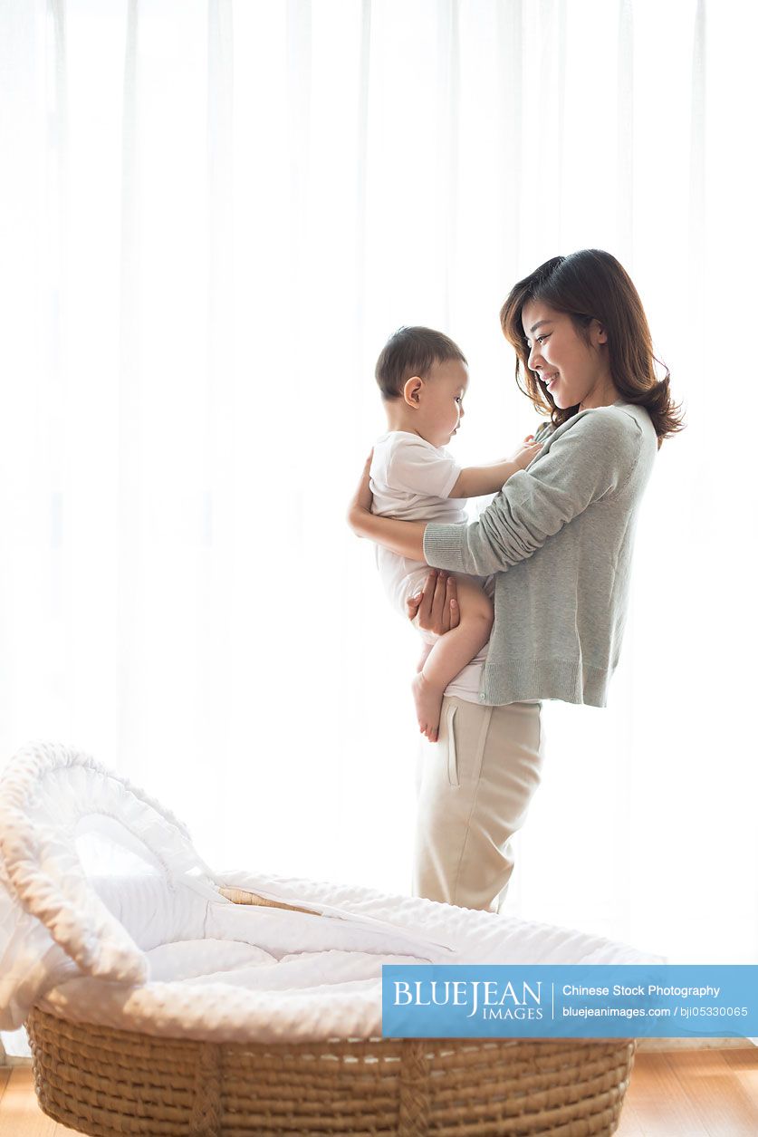 Happy Chinese mother and cute baby at home