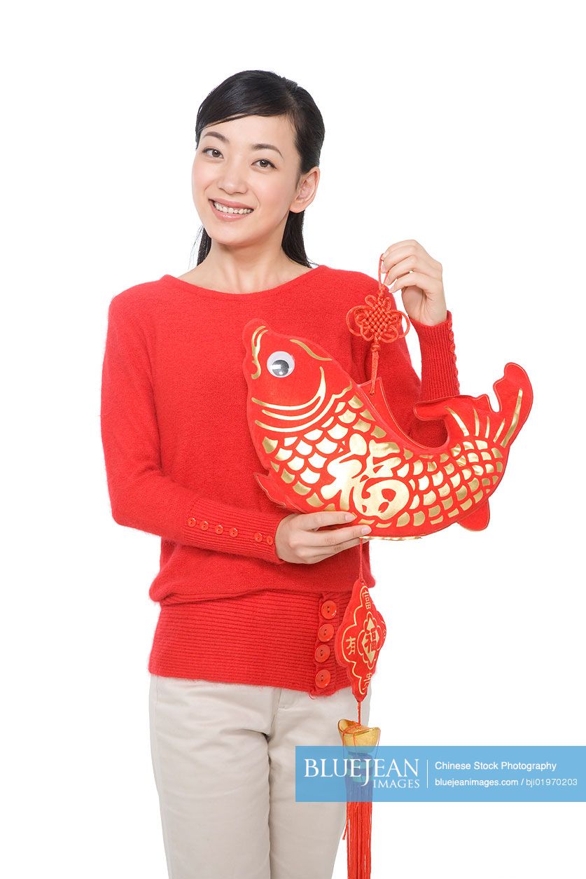 Young Chinese woman holding decorative red fish