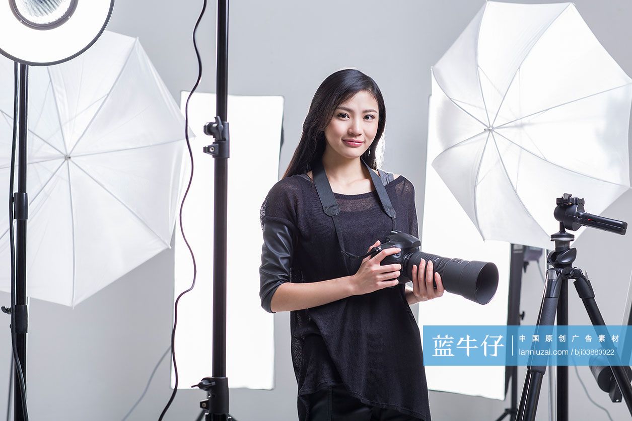 摄影师拿着相机站在摄影棚里