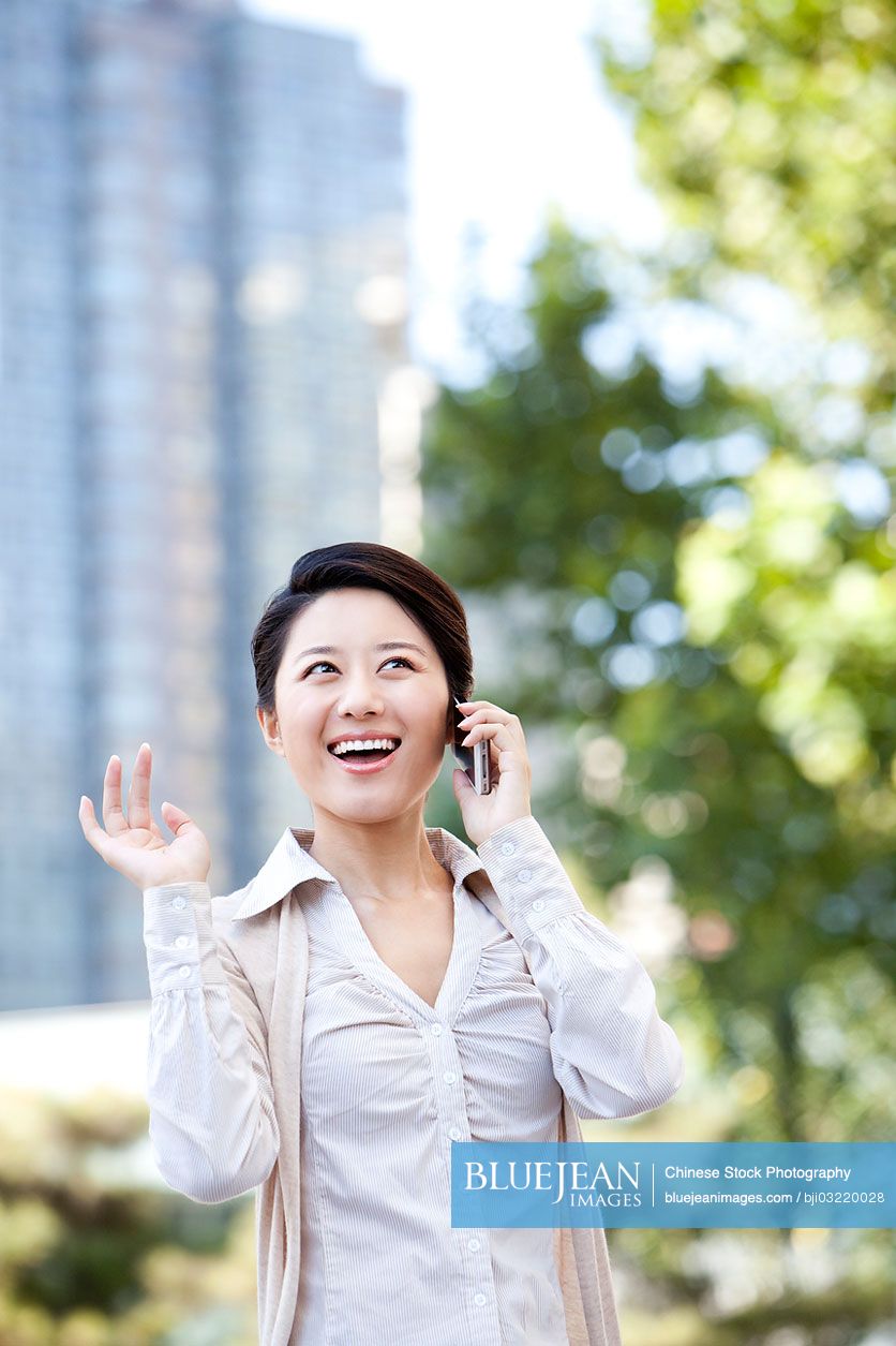 Smiling Chinese businesswoman on the phone