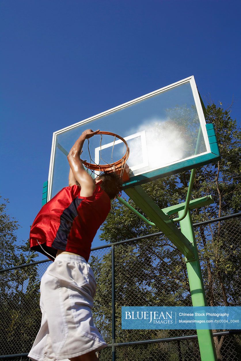 Young Chinese man playing basketball