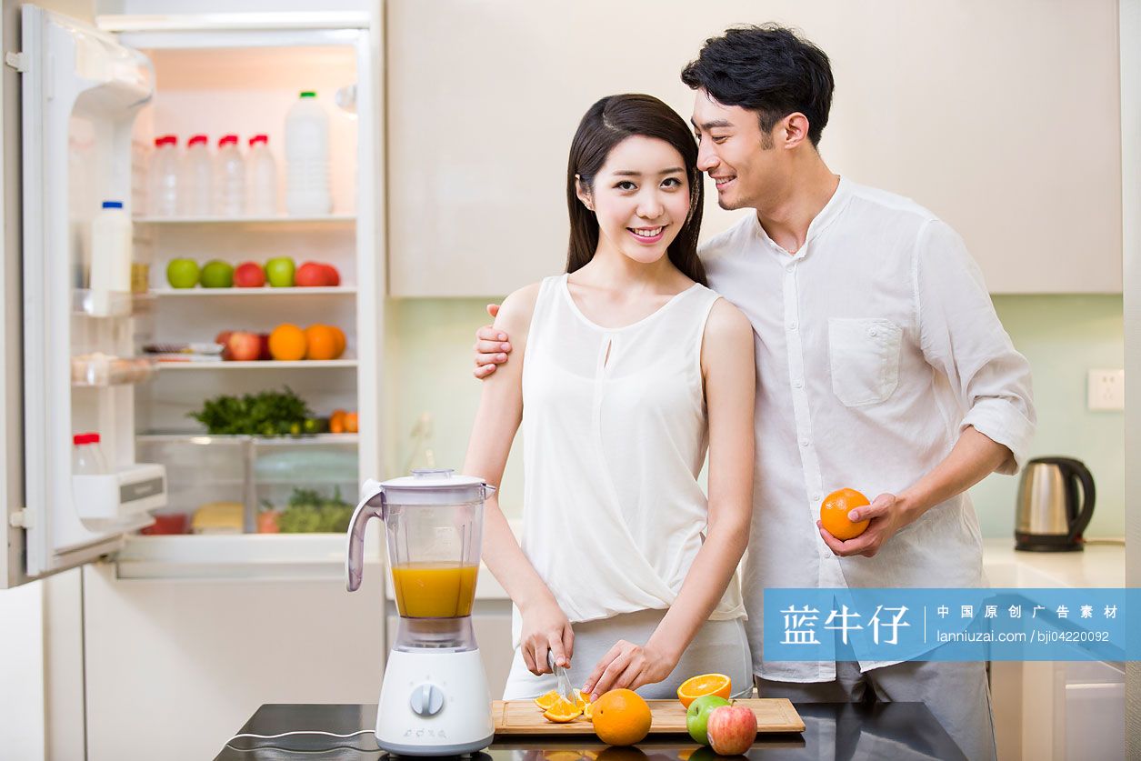 年轻夫妇在厨房切橙子