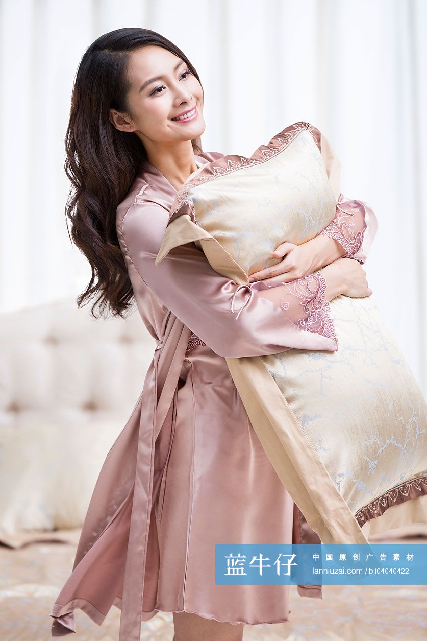 年轻女性抱着枕头