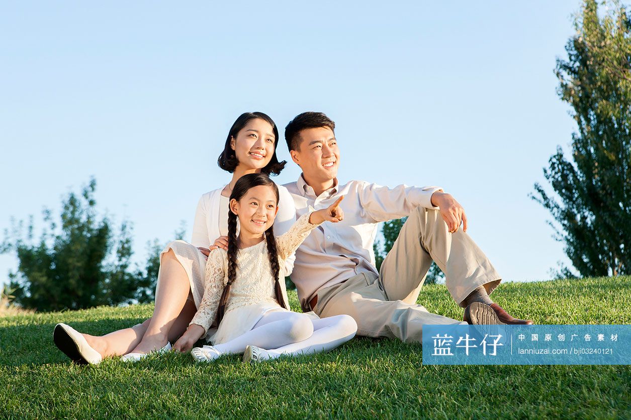 快乐的一家三口坐草地上