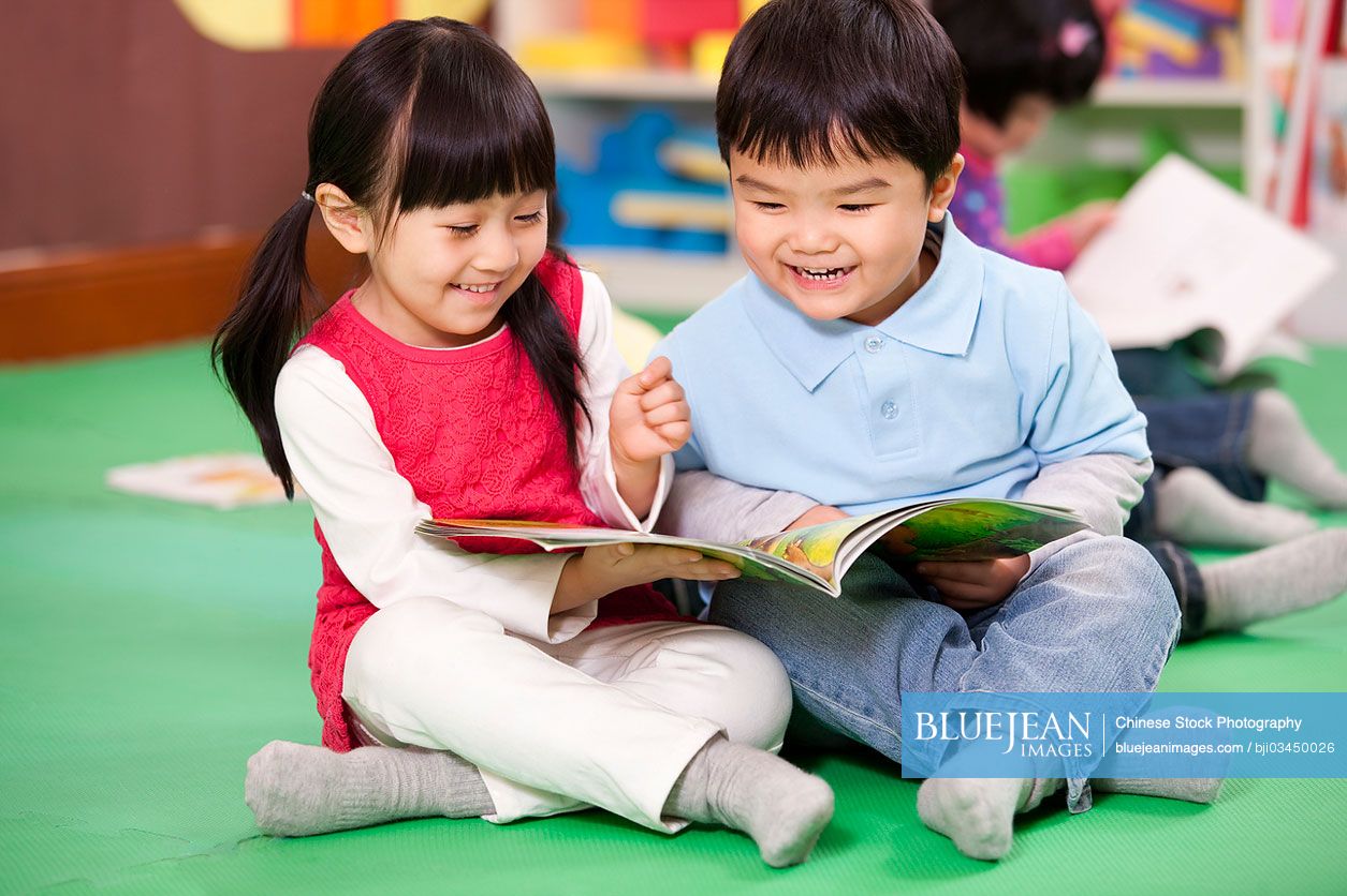 Cute little Chinese girl and little boy reading books
