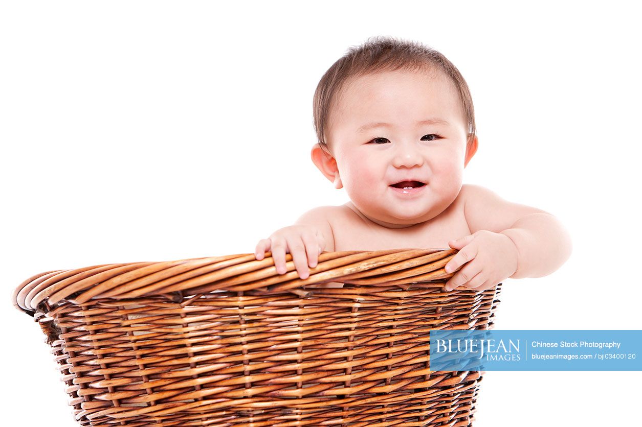 Happy Chinese baby girl in a bamboo basket