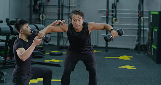 Mature Chinese man working out with personal trainer at gym,4K