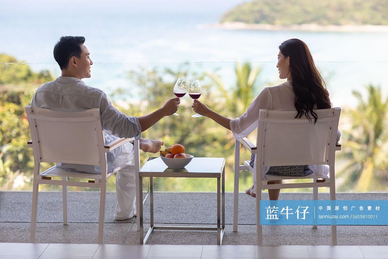 年轻夫妇在露台喝红酒