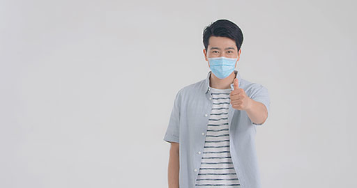 Young Chinese man with surgical mask doing thumbs-up,4K