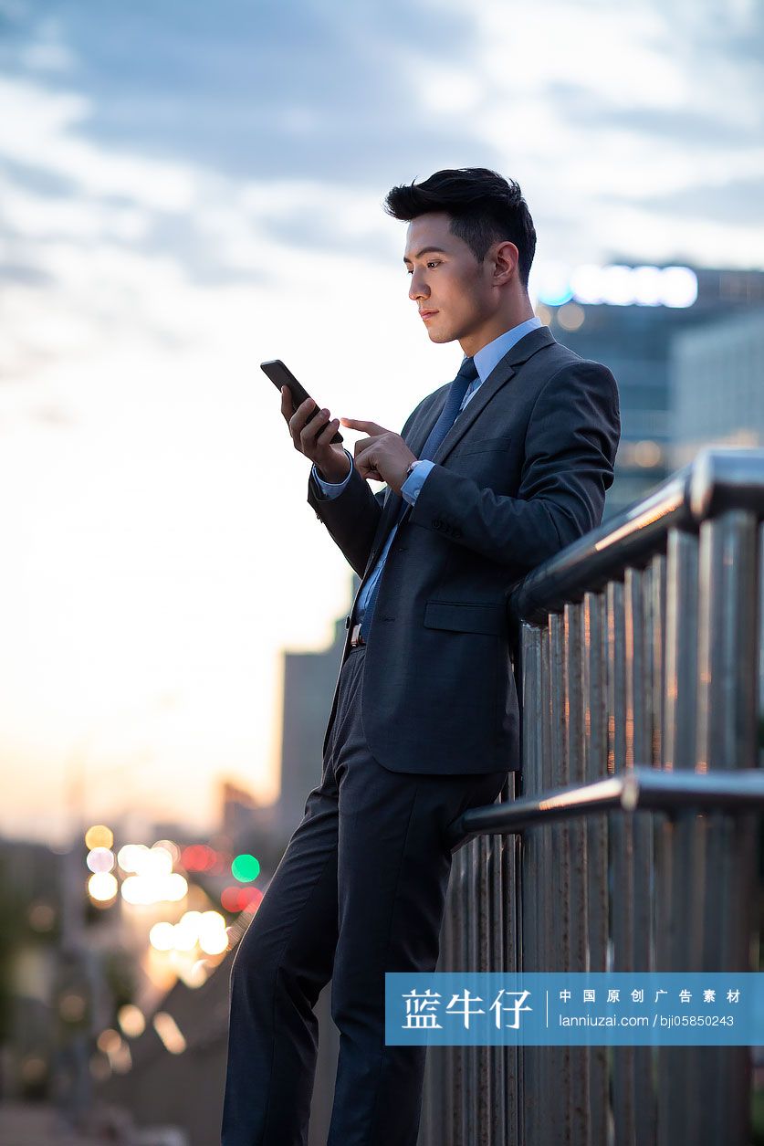 自信的年轻商务男士使用手机