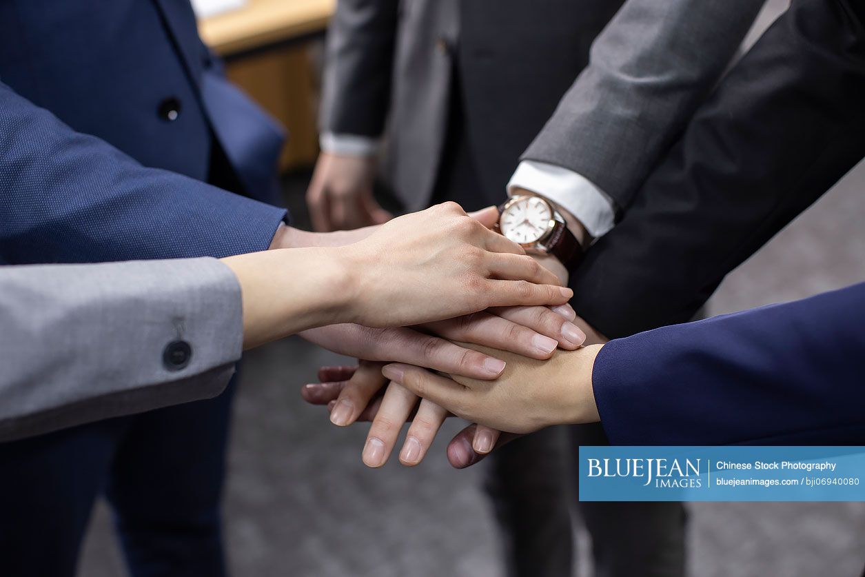 confident-chinese-business-people-cheering-in-office-high-res-stock