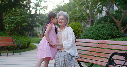 Happy Chinese grandmother and granddaughter talking in park,4K